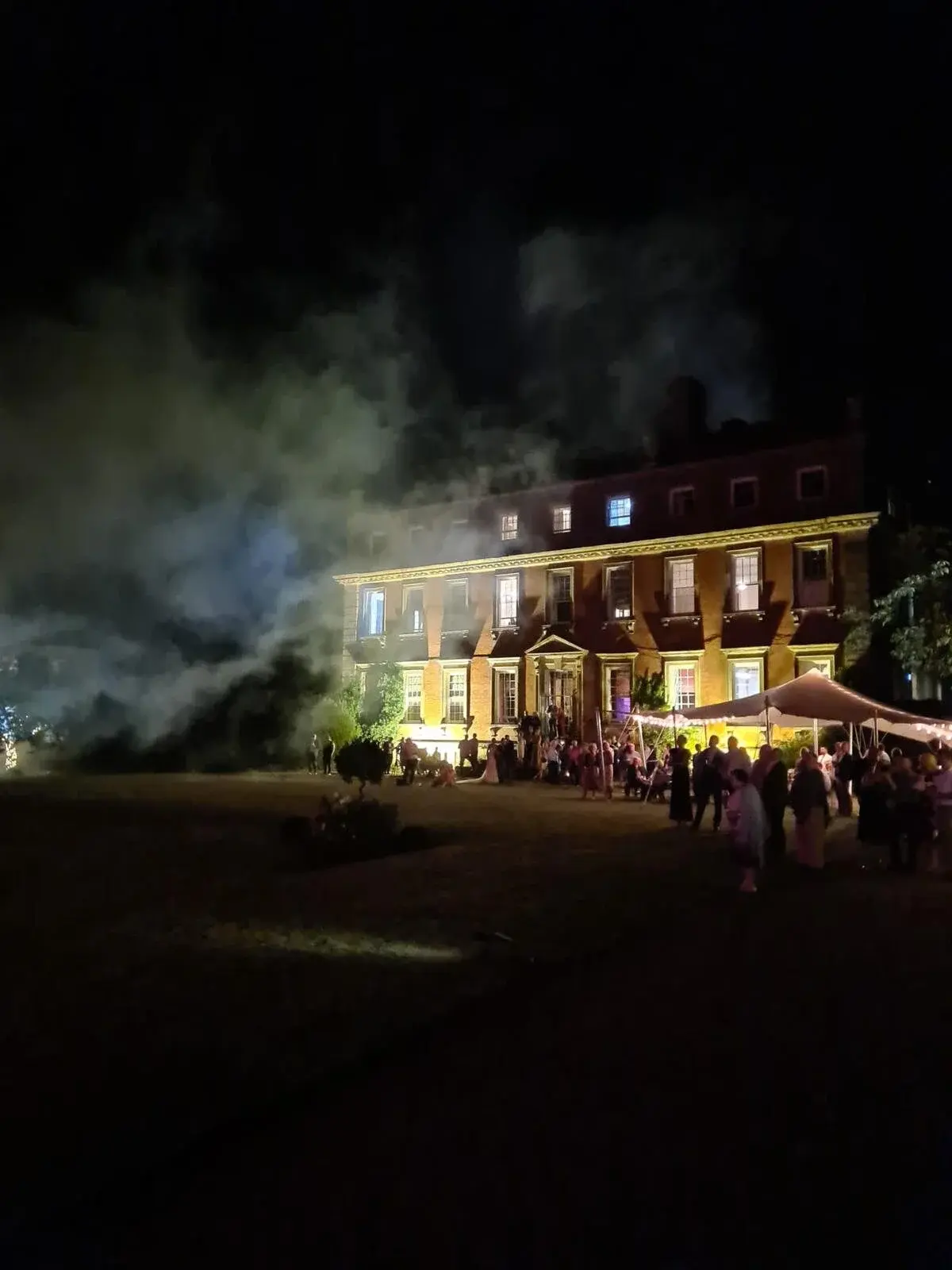 Stretch tent lit up at night at a country house party